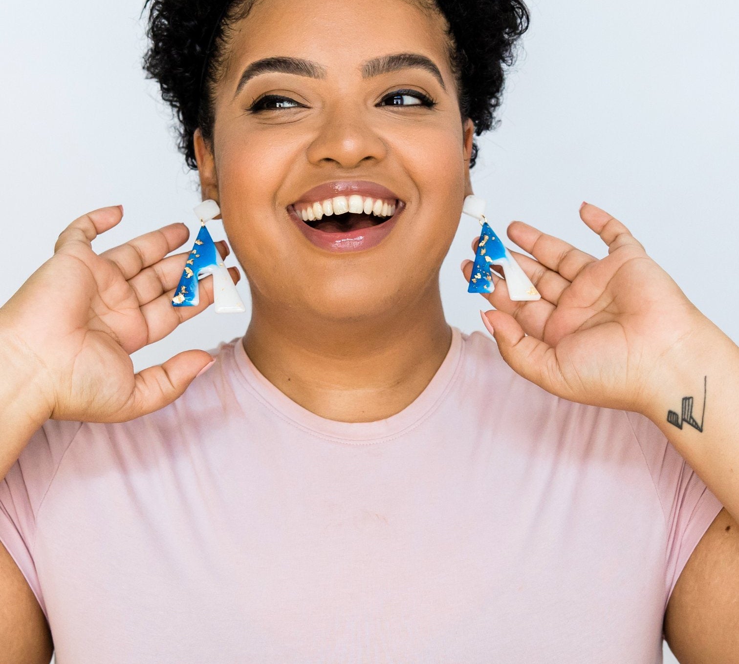 Girl smiling and showing off earrings