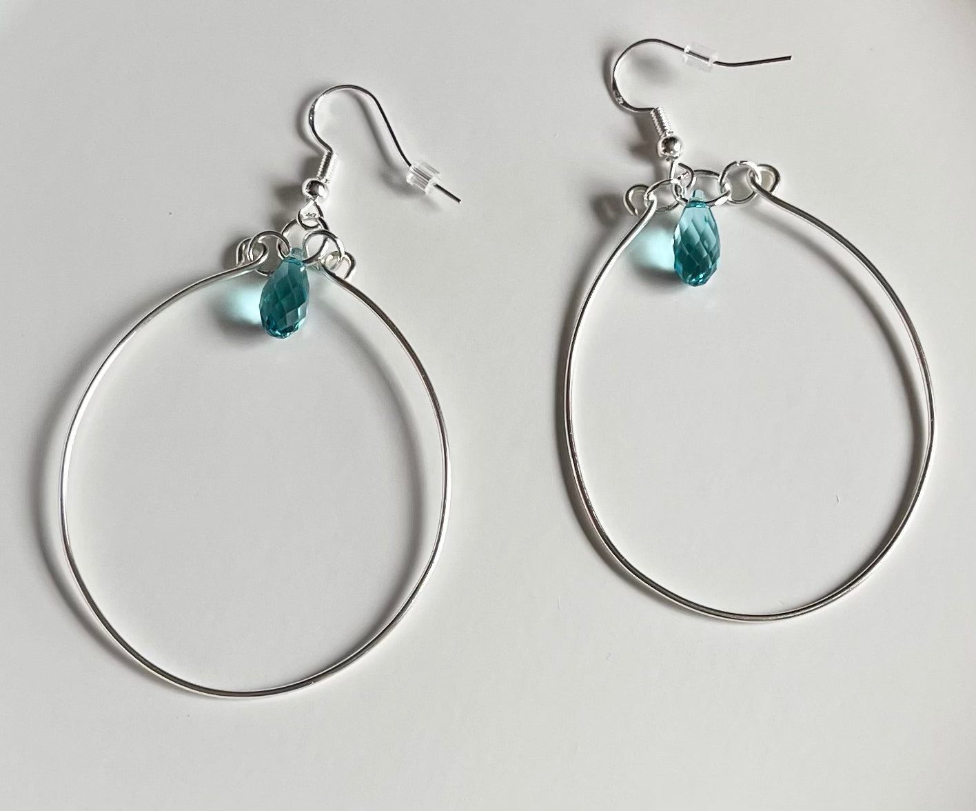 Silver wire hoop earrings with blue crystal