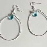 Silver wire hoop earrings with blue crystal