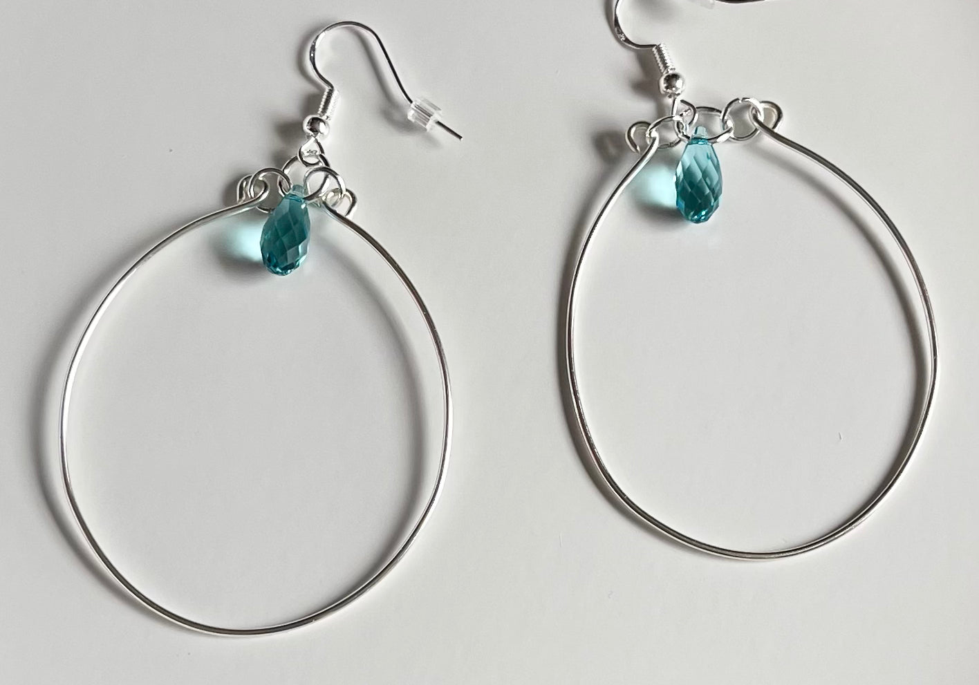 Silver wire hoop earrings with blue crystal