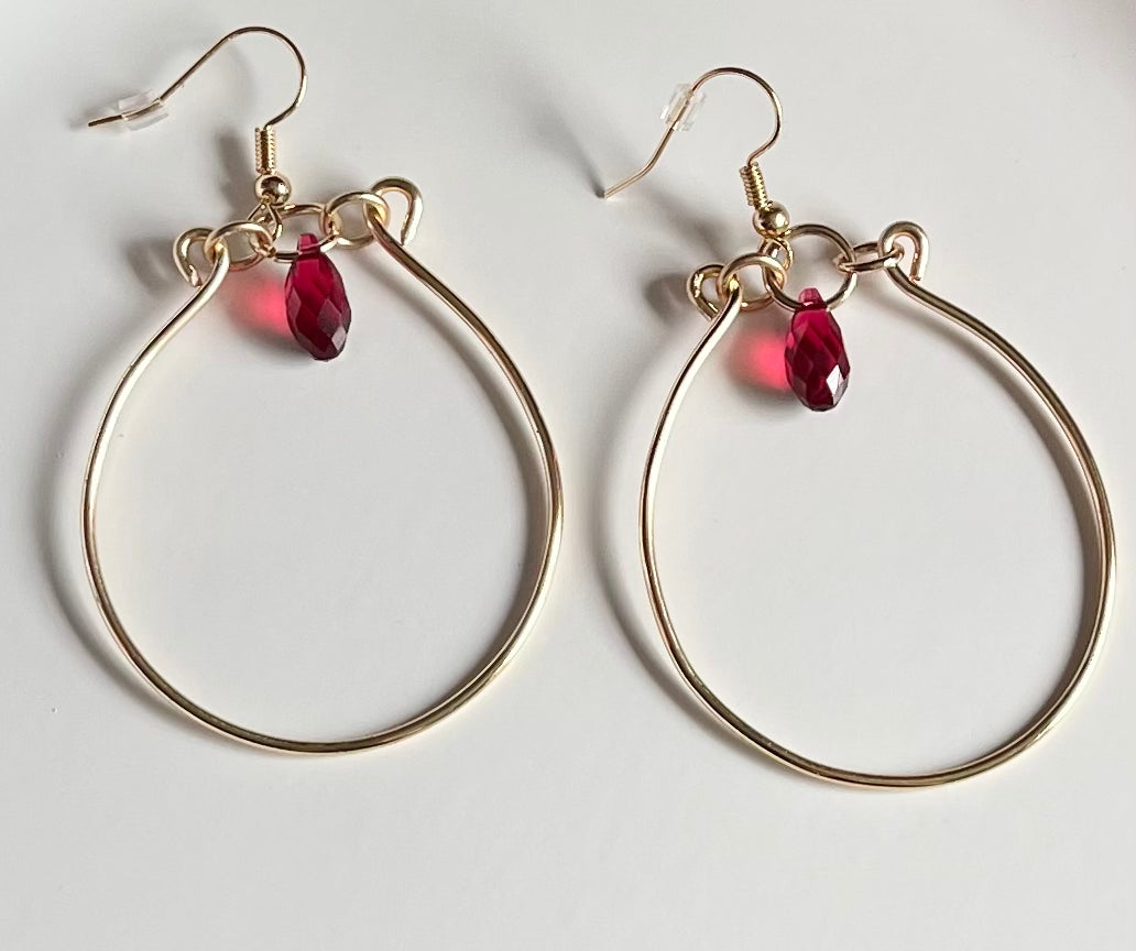 Gold wire hoop earrings with red crystal
